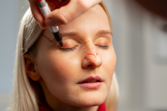 close up in a plastic surgery clinic doctor makes markings on the face of a young girl before surgery
